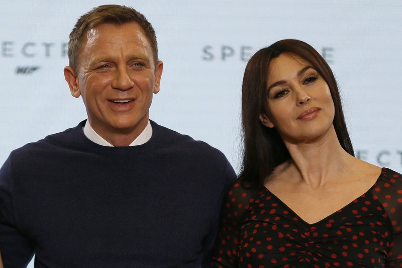 Actors Daniel Craig and Monica Bellucci pose on stage during an event to mark the start of production for the new James Bond film "Spectre" at Pinewood Studios